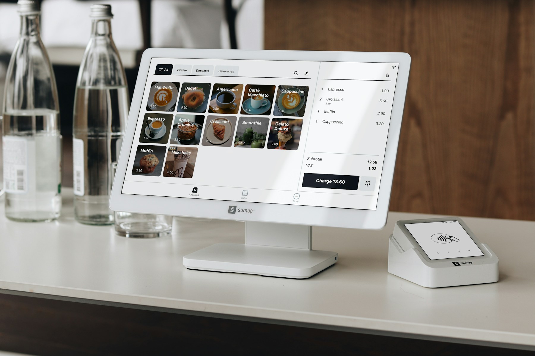 Countertop POS system and card reader on a café counter for menu navigation and secure checkout.