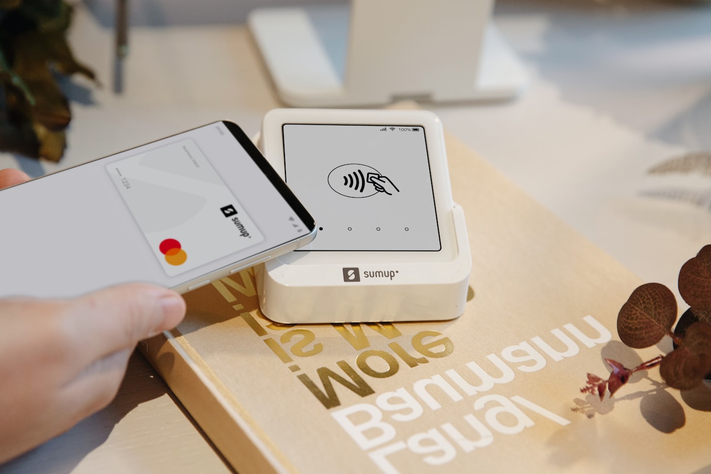 Customer completing a contactless tap-to-pay on a smartphone paired with a compact mobile card reader.