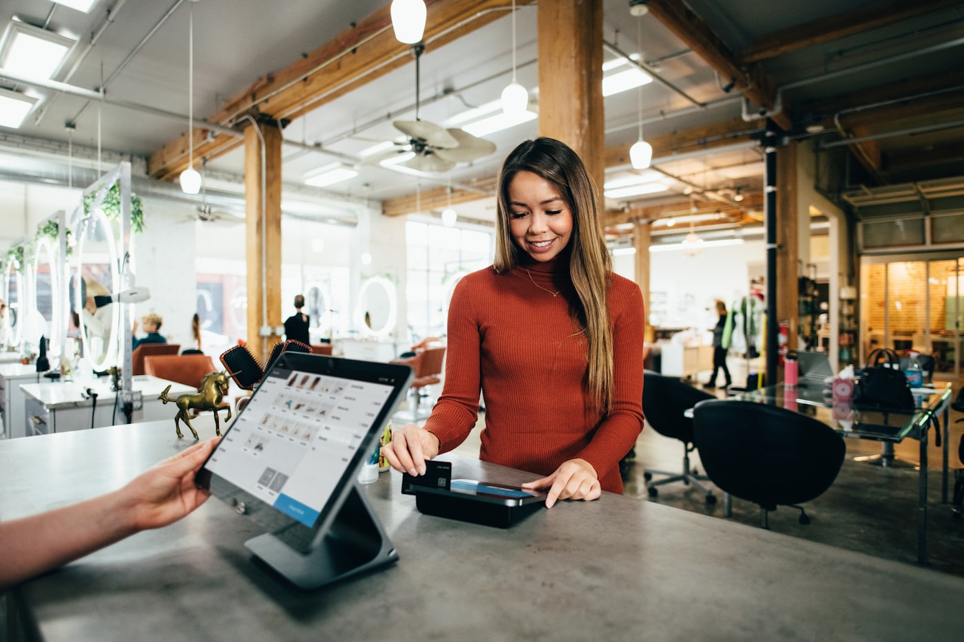 Touchscreen point-of-sale register at a modern retail counter during a card-present sale.